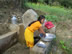 Une femme utilise une des fontaines pour faire le lavage de la semaine.